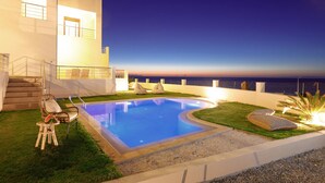 A modern outdoor pool area with a clear view of the ocean, a staircase leading to a balcony, and a lounge chair. - Peach- Sea View Exclusive Maisonette (Rethymno)