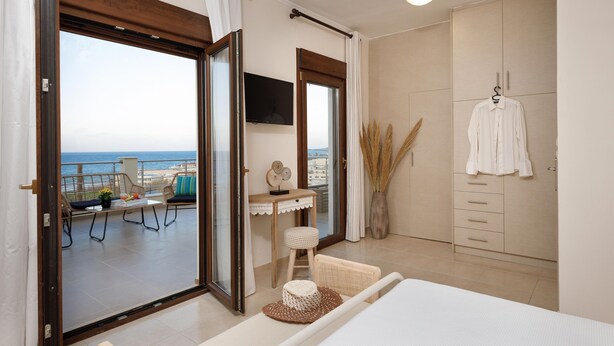 A bedroom with a balcony, a desk, a TV, and a wardrobe. - Peach- Sea View Exclusive Maisonette (Rethymno)