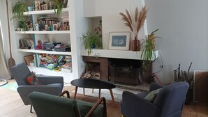 A living room with a fireplace, bookshelves, and seating. - Large, cosy house near the town center (Nantes)