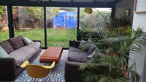 A modern living room with a large glass door leading to a garden. - Large, cosy house near the town center (Nantes)