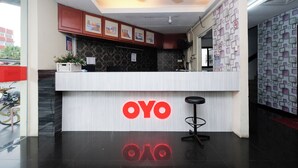 Ένας χώρος υποδοχής με έναν λευκό πάγκο, έναν ανεμιστήρα οροφής, φωτογραφίες σε  κορνίζες στον τοίχο και έναν τοίχο με διακοσμητικό σχέδιο στα δεξιά.