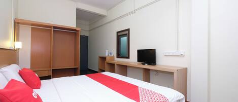 A hotel room with a bed, a TV, a desk, and a wardrobe.