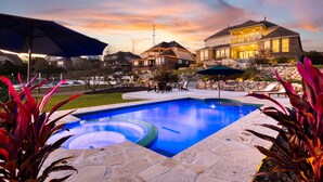 Une propriété résidentielle dotée d’une piscine, de mobilier d’extérieur et d’un jardin bien entretenu.