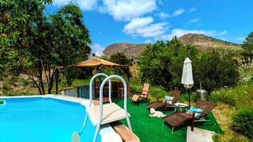 Een seizoensgebonden buitenzwembad en parasols bij het zwembad