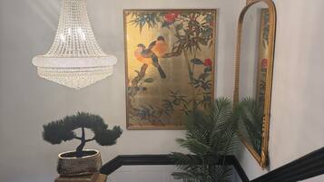Un candelabro, un cuadro enmarcado, un espejo, un bonsái y una escalera.