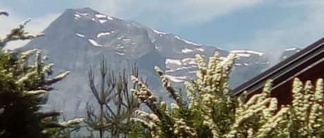 Een berg met besneeuwde toppen en een heldere lucht.