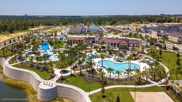 A resort with multiple buildings, a large central pool, and a surrounding landscaped area. - HOGARTS & AVATAR! MARIO Kart! Pool with Waterpark Close to Disney! (Kissimmee)