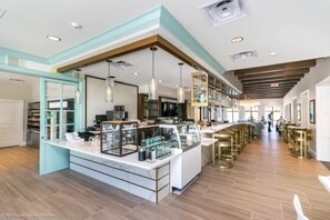 Een moderne keuken met een centraal eiland, hanglampen en een bar voorzien van krukken.