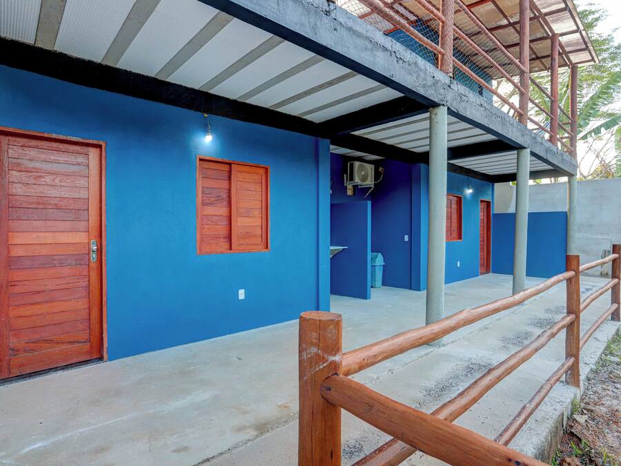 Un edificio con paredes azules, puertas de madera y piso de concreto.