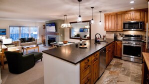 A modern kitchen with wooden cabinets, stainless steel appliances, and a central island. - 3BR/2BA, Ski in/out from A/B lift, pool & hot tub (Ludlow)
