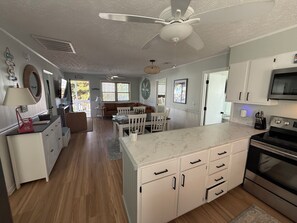 A spacious kitchen with white cabinetry, a marble countertop, and a modern stove. - Charming and cozy house in Sunset Beach and only a 5 min walk to the beach! (Sunset Beach)