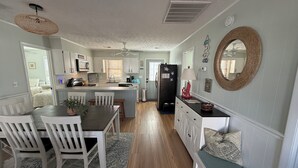 Une cuisine spacieuse avec un coin repas, un plancher en bois et un îlot central.