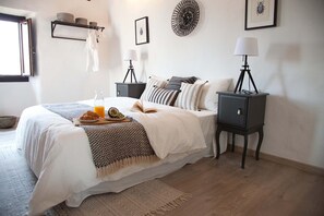 A neatly arranged bedroom with a bed, bedside tables, a lamp, and a bedside shelf.