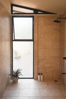 Bungalow Deluxe, vistas al jardín | Baño | Ducha, cabezal de ducha tipo lluvia, toallas y jabón