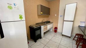 Eine kleine Küche mit Kühlschrank, Herd und Spüle.