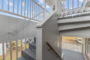 A staircase with a handrail and a view of a parking area with vehicles. - Unique Top-Floor Apt in BTV (Burlington)