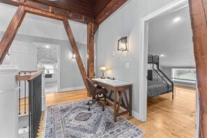 Ein Schlafzimmer im Loft-Stil mit Schreibtisch, Stuhl und Bett.
