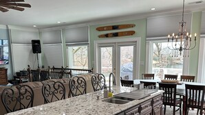 A spacious kitchen with a large island, dark wood cabinets, and a granite countertop. - Family-Friendly Lakefront Home with Hot Tub, Firepit, Dock & Breathtaking Views! (Charlotte)