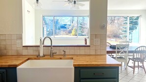 A kitchen with a large window, wooden countertop, and a sink. - 4 Bedroom Beachside Surfer's Home (South Portland)