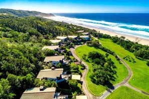 Zona residencial costera con casas, playa y campo de golf.