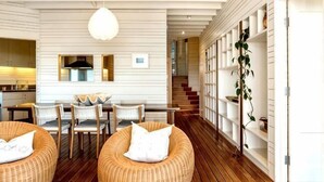 Un intérieur moderne comprenant un coin repas, un plancher en bois et un escalier menant à un autre niveau.
