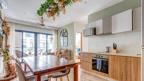 Una cocina moderna con armarios de madera, horno empotrado y un ventanal amplio.