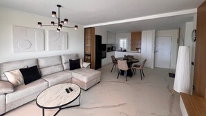 A modern living room with a sofa, a coffee table, and a dining area with chairs and a table. - Casa Margarita, Costa Adeje (Costa Adeje)