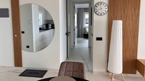 A modern living room with a large mirror, a clock, and a tall floor lamp. - Casa Margarita, Costa Adeje (Costa Adeje)