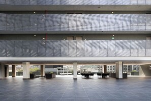 A multi-level open-plan space with a modern design, featuring a central seating area and multiple levels with a patterned facade. - Modern Apts w Pool & Mountain View (Santa Catarina)