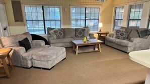 A living room with two grey sofas, a wooden coffee table, and a white table.
