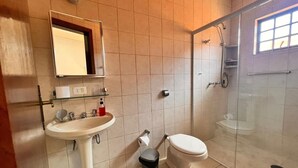 A bathroom with a sink, toilet, and glass-enclosed shower.