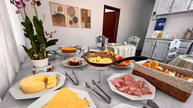 A breakfast buffet with various cheeses, meats, and fruits.