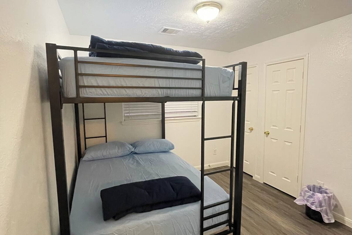 Ein Stockbett in einem Zimmer mit Holzboden und weißen Wänden.