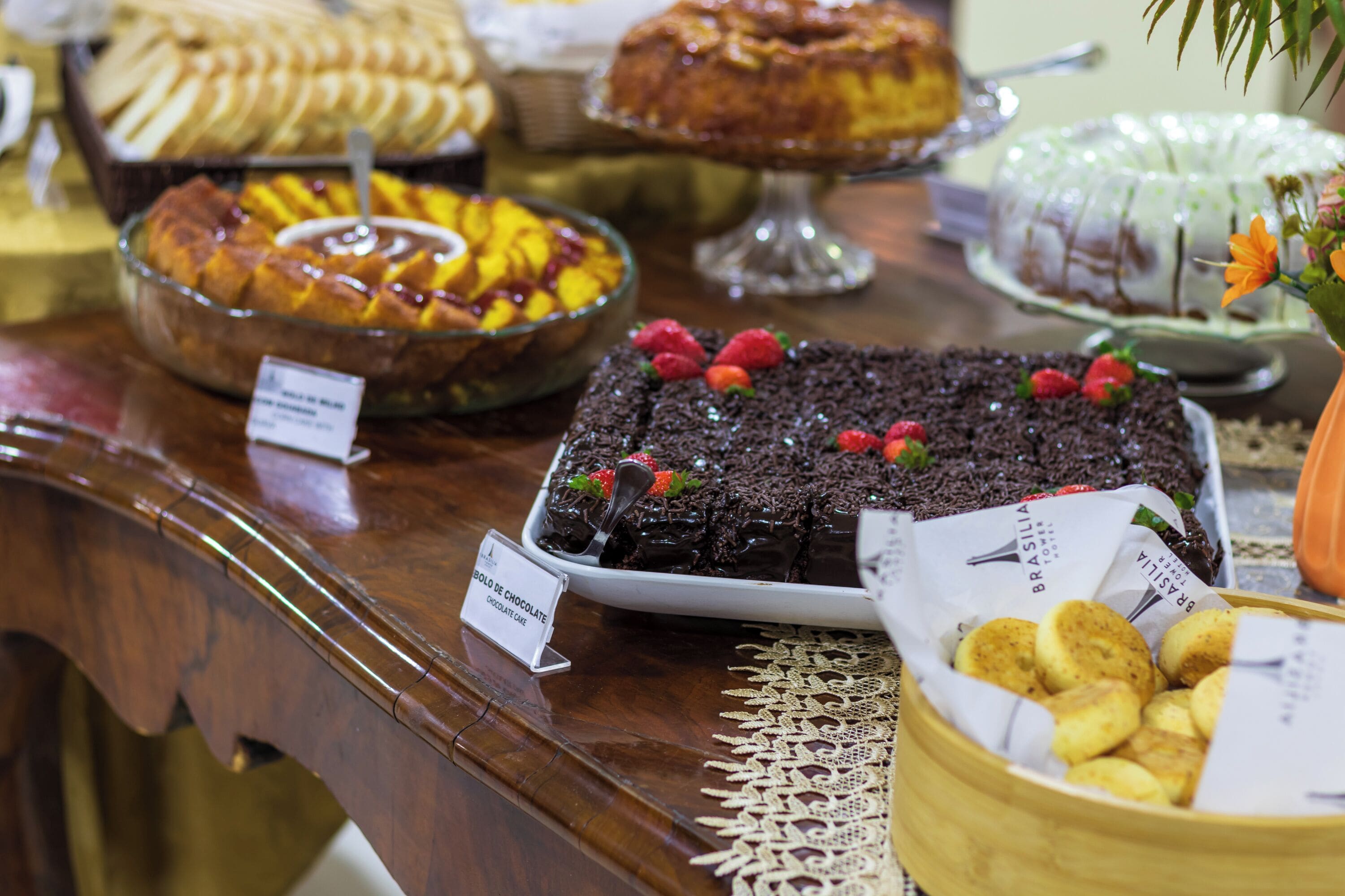 A buffet table with various desserts including a chocolate cake, fruit, and pastries.