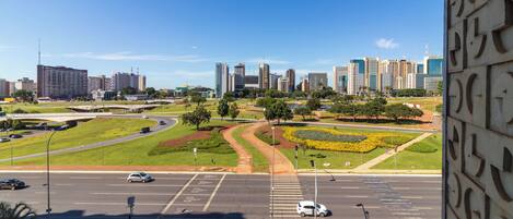 Un paisaje urbano con edificios modernos, un área verde con parque y una carretera con vehículos.