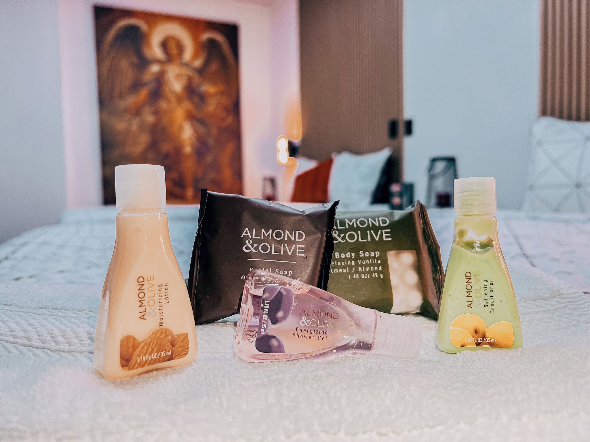 Variedad de productos de cuidado personal sobre una cama con textura suave.