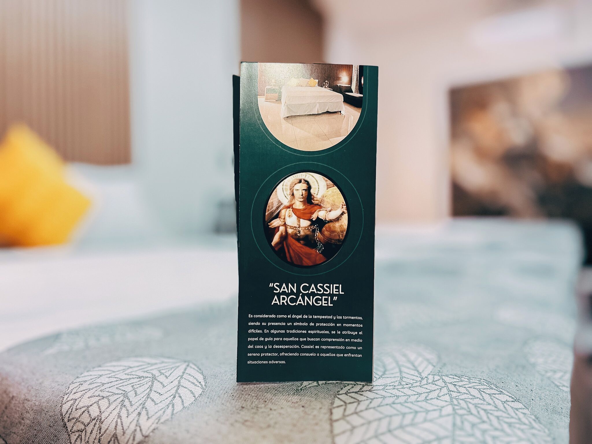 A brochure titled "SAN CASSIEL ARCÁNGEL" with a circular image of a bed and a figure.