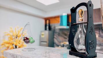 Uma bancada de cozinha com um jarro de vidro decorativo e uma cesta de frutas pendurada.