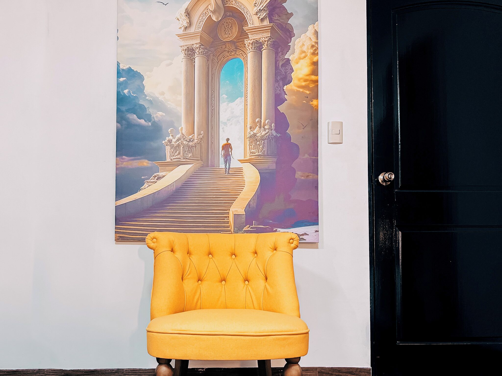Un sillón amarillo frente a una pared con un cartel grande de un arco clásico y una persona caminando hacia él.
