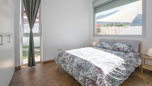Une chambre à coucher avec un lit, une fenêtre donnant sur un beau paysage et un rideau.
