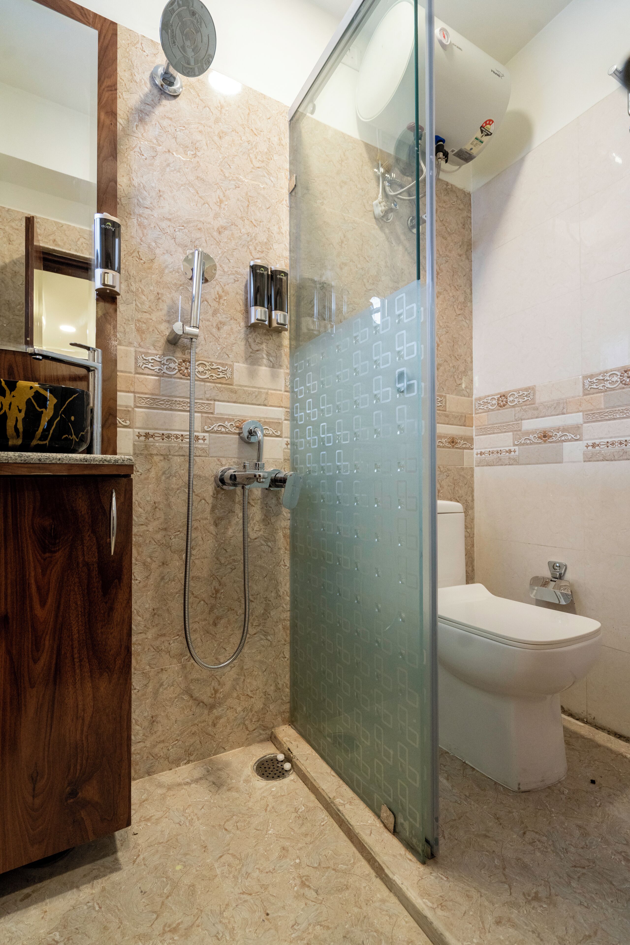 A modern bathroom with a glass shower enclosure, a wooden vanity, and a toilet.