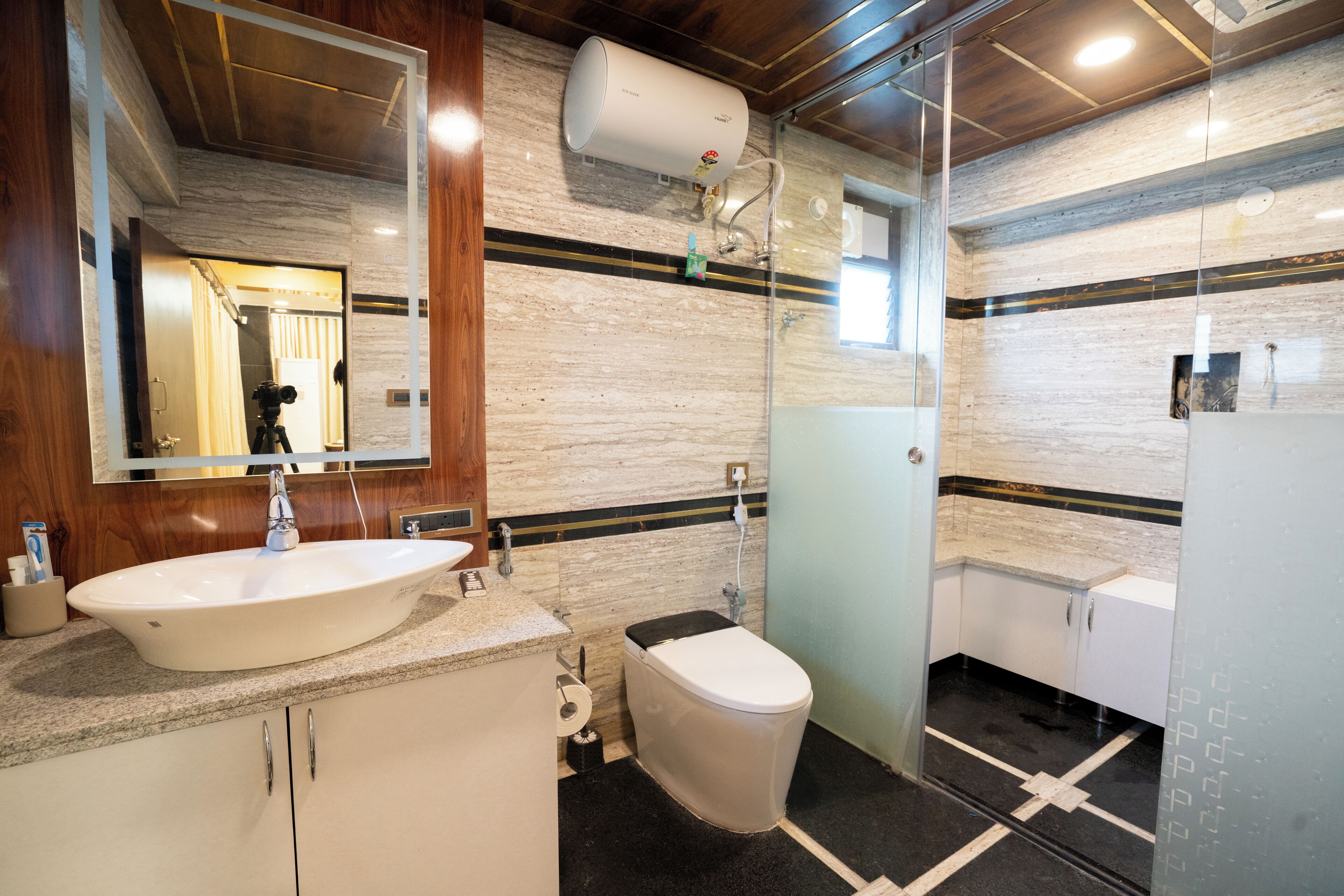 Un baño moderno con un lavamanos grande blanco, un inodoro y una cabina de ducha de vidrio.