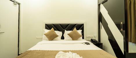 Una habitación de hotel con una cama, un teléfono y un espejo.