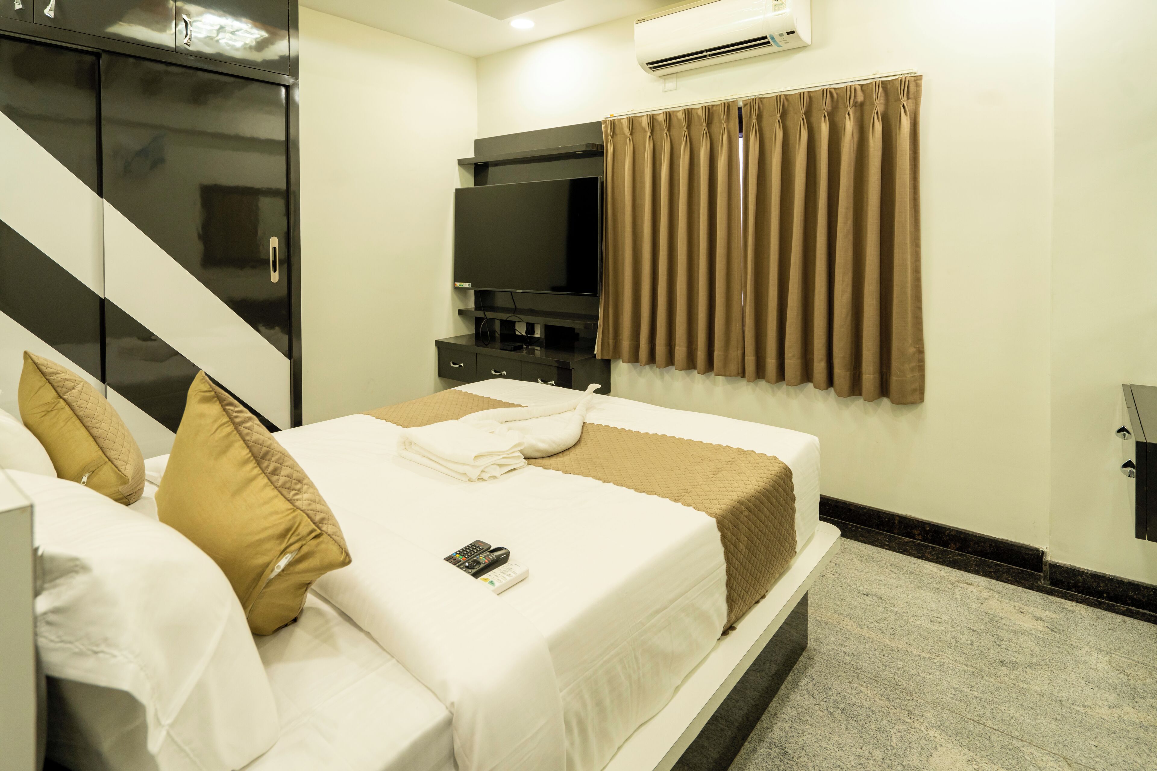 Habitación de hotel con cama, televisión y armario.