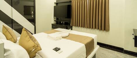 Habitación de hotel con cama, televisión y armario.