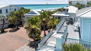 Une propriété située sur la côte, comprenant plusieurs bâtiments, une cour pavée et offrant une vue sur la plage et l’océan.