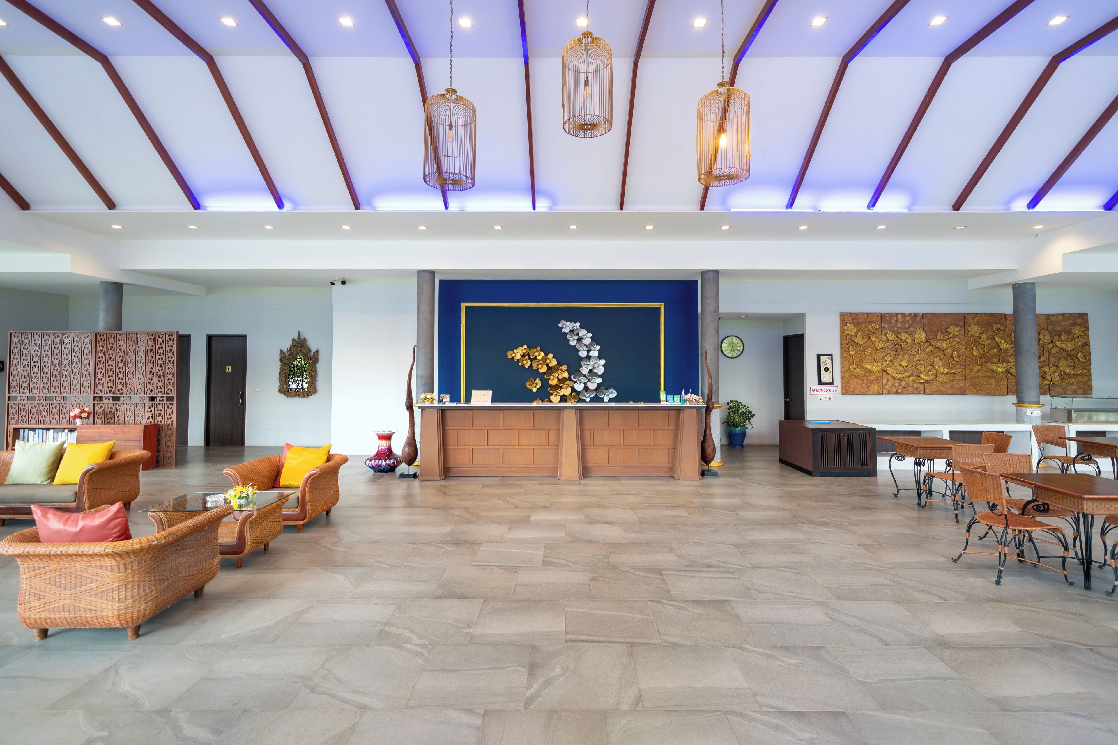 A spacious lobby with a reception desk, seating area, and a large decorative wall.