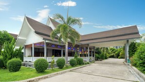A modern hotel with a covered outdoor area, palm trees, and well-maintained greenery. - Phuket La Siesta Pool Villa And Pool Access (Rawai)