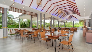 A spacious outdoor dining area with wooden tables and chairs, a modern ceiling design, and a view of greenery. - Phuket La Siesta Pool Villa And Pool Access (Rawai)