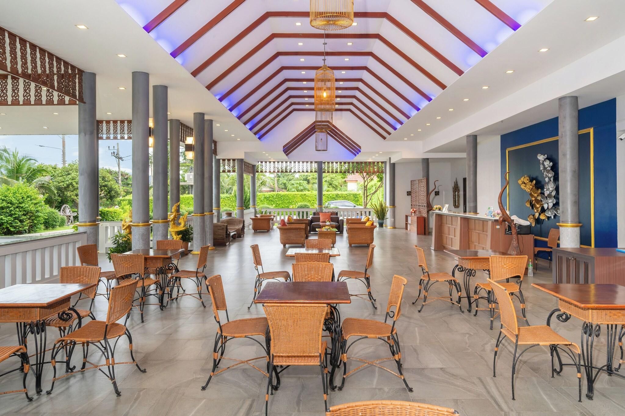 A spacious indoor area with multiple seating arrangements, including tables and chairs, and a reception desk.